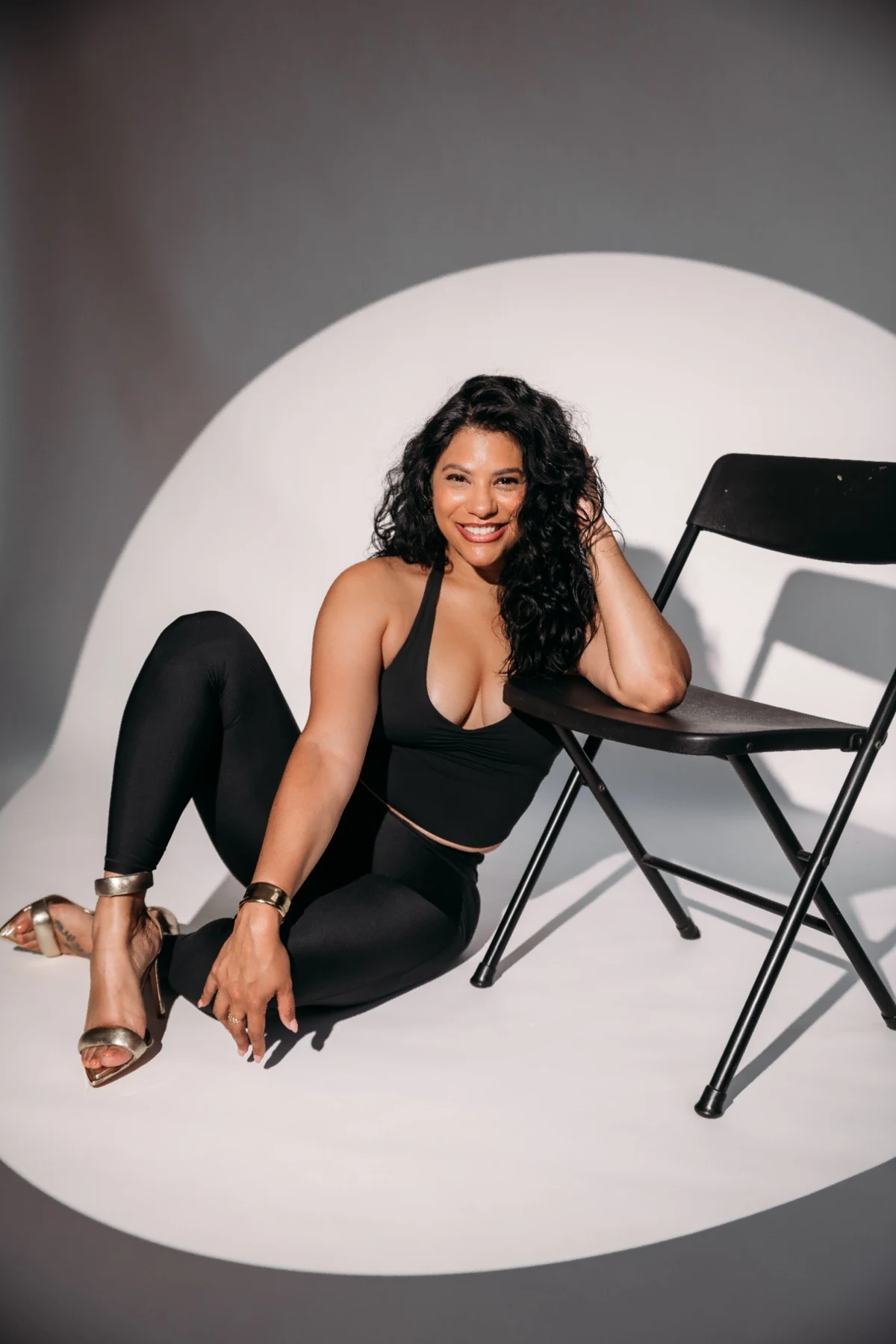 Shay smiling beside a chair